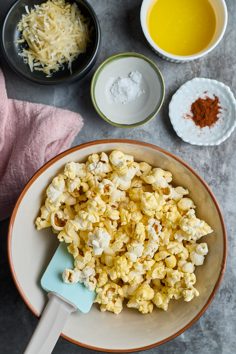 Toss popcorn with melt butter and cheese and spices.