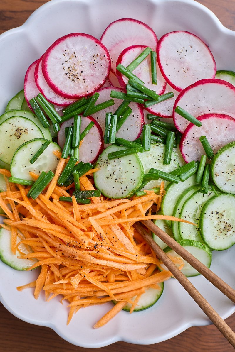 Add all salad vegetables to dressing in bowl and toss to combine.