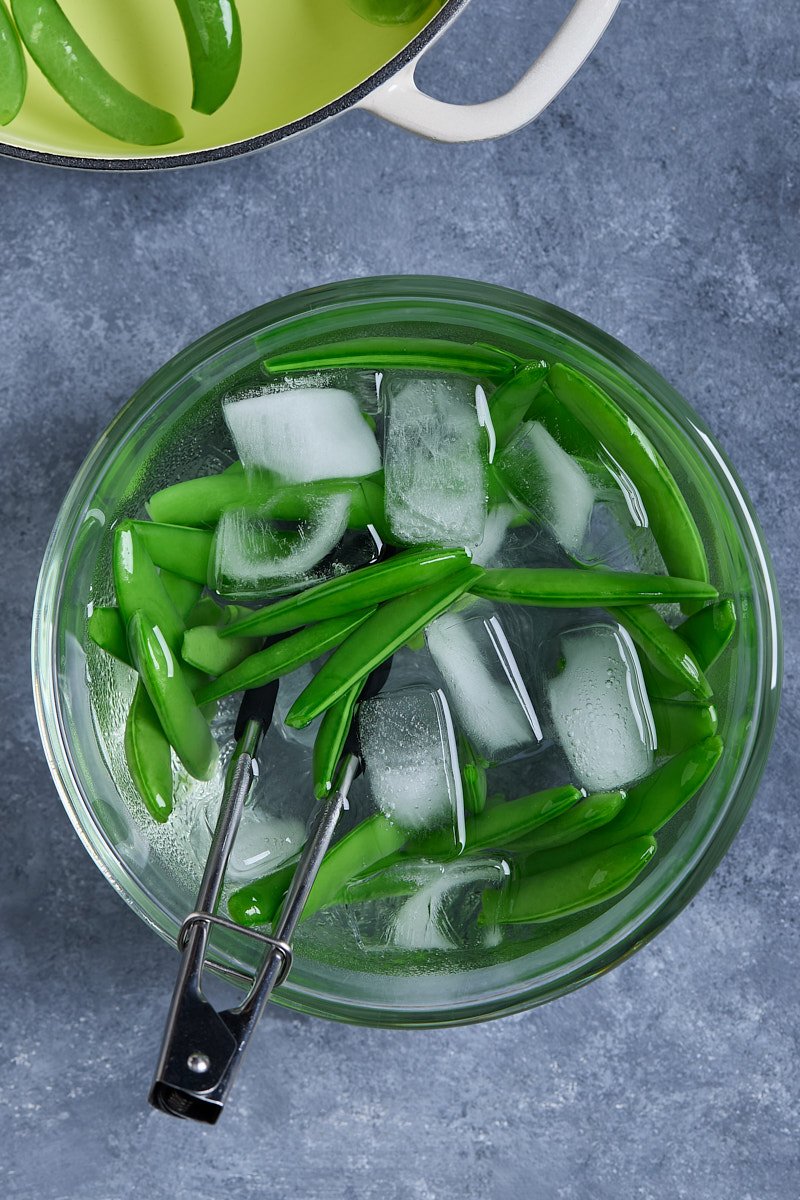 Transfer green beans to a bowl of ice water.