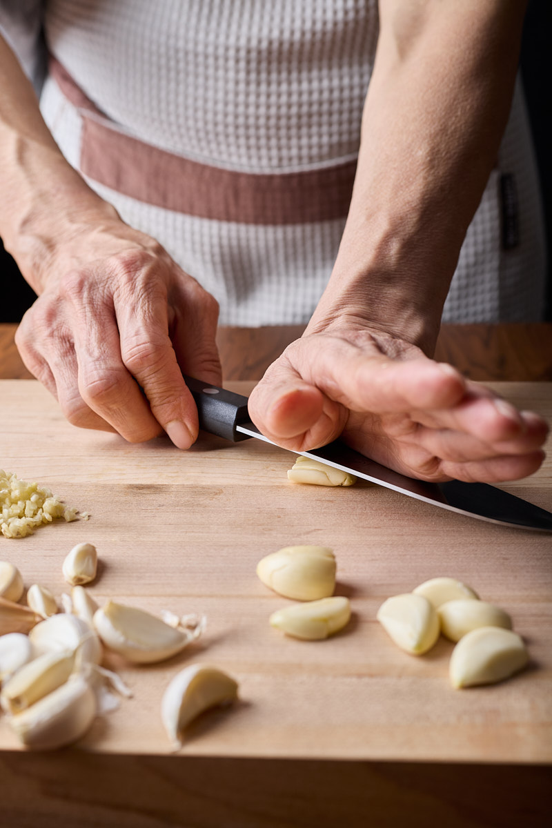 Put the garlic cloves on the cutting board.