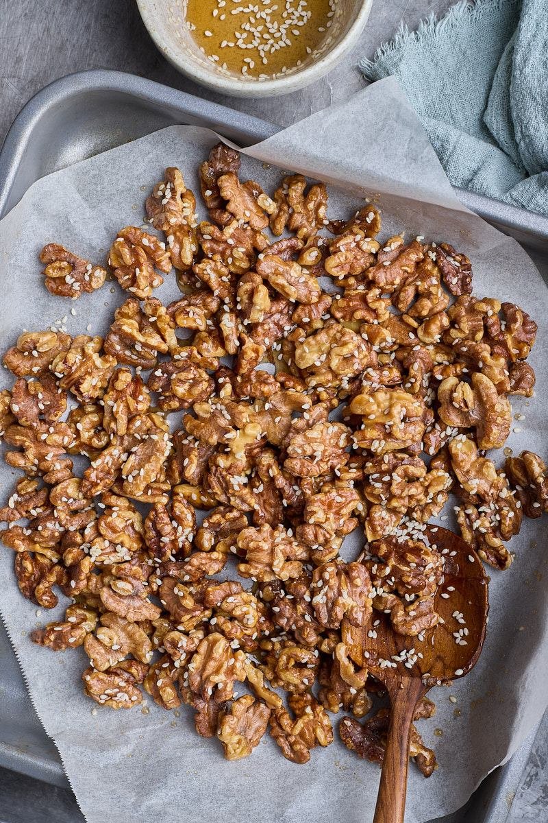 Drizzle syrup mixing over the warm nuts.