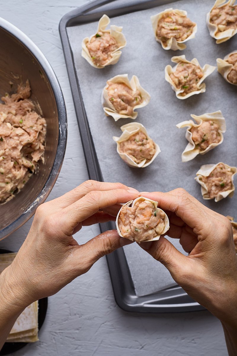 Use your hand and finger to flatten the bottom and compact dumpling.