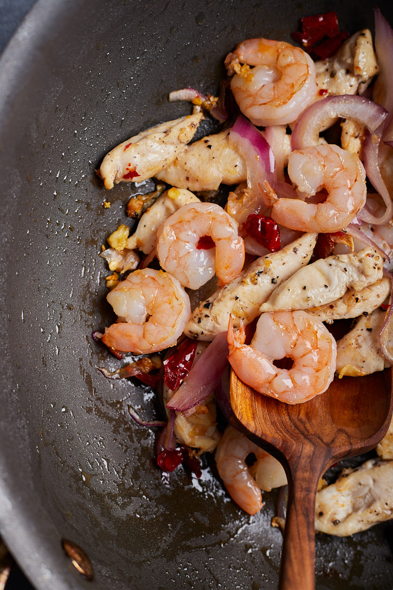 Cook shrimp and chicken in aromatic wok.