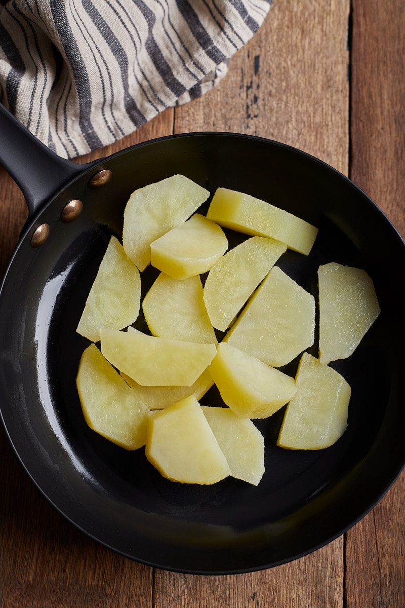 Cook and sear potatoes in the skillet.